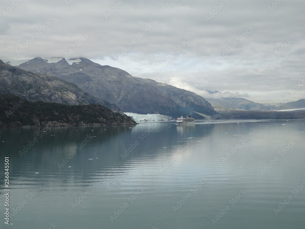 Glacier in the midst of gray mountains with little vegetation in Alaska