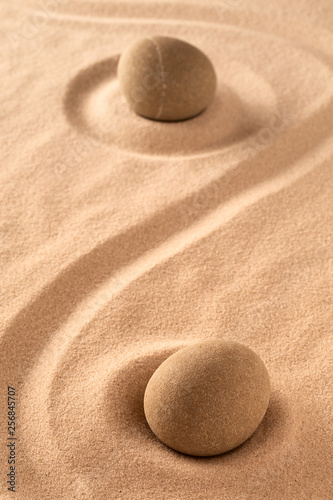 zen meditation stone in raked sand.