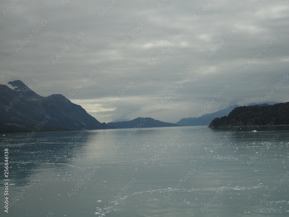 Passage in the Pacific Ocean between two mountain ranges. Calm peaceful waters flowing slowly under a cloudy sky. Passage in the Pacific Ocean between two mountain ranges. Calm peaceful waters flowing slowly under a cloudy sky.