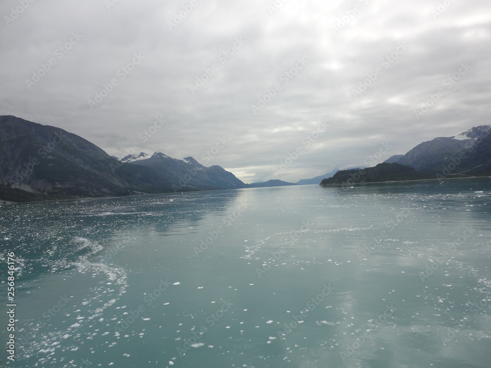 Fototapeta premium Passage in the Pacific Ocean between two mountain ranges. Calm peaceful waters flowing slowly under a cloudy sky.