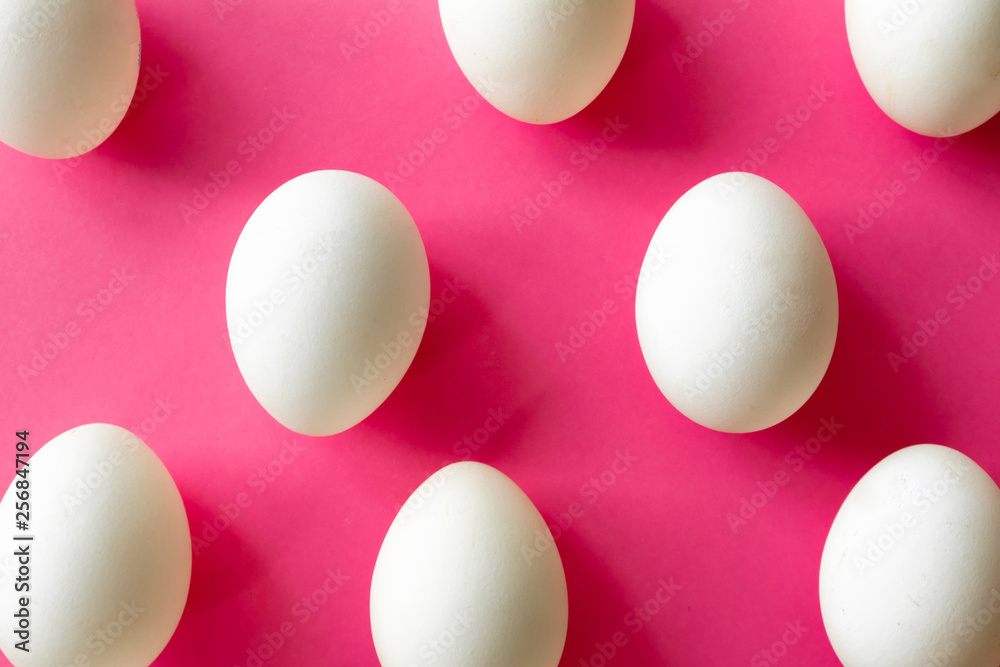 White eggs on fuchsia color background, top view White eggs on fuchsia color background, top view