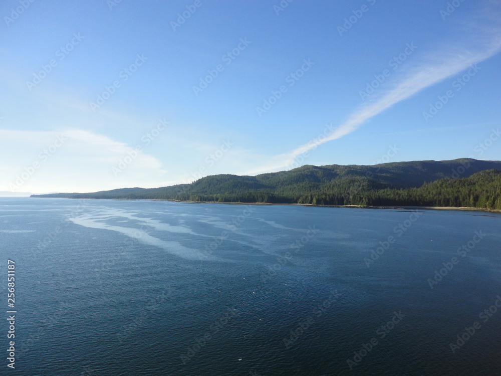 Passage in the Pacific Ocean between two mountain ranges. Calm peaceful waters flowing slowly under a cloudy sky. Passage in the Pacific Ocean between two mountain ranges. Calm peaceful waters flowing slowly under a cloudy sky.