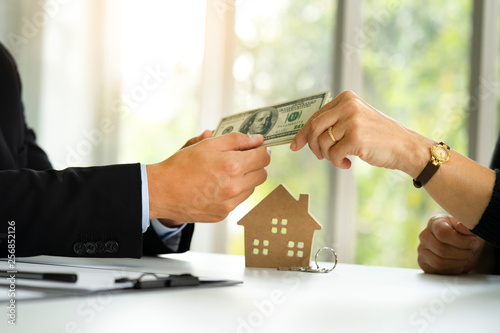 Fotografi Banker receiving deposit payment by dollars cash from buyer who signed loan or m