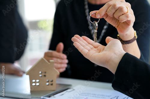 Real estate manager agent giving keys to buyer or investor who's owner of resident or land after credit approved by bank, deposit payment and agreement or contract completely signed at office.........