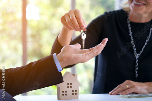 Canvas Print Real estate manager agent giving keys to buyer or investor who's owner of resident or land after credit approved by bank, deposit payment and agreement or contract completely signed at office