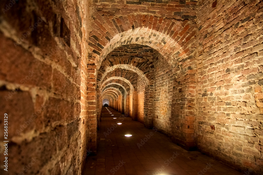 underground catacombs with red brick illuminated