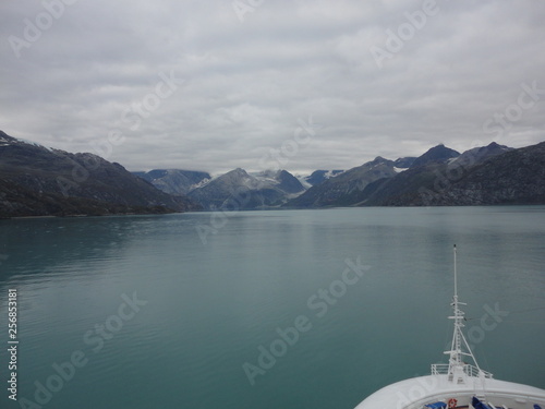 Mountain Filled horizon on the pacific ocean. Inside passage Alaska with glaciers at the peaks under a cloudy sky