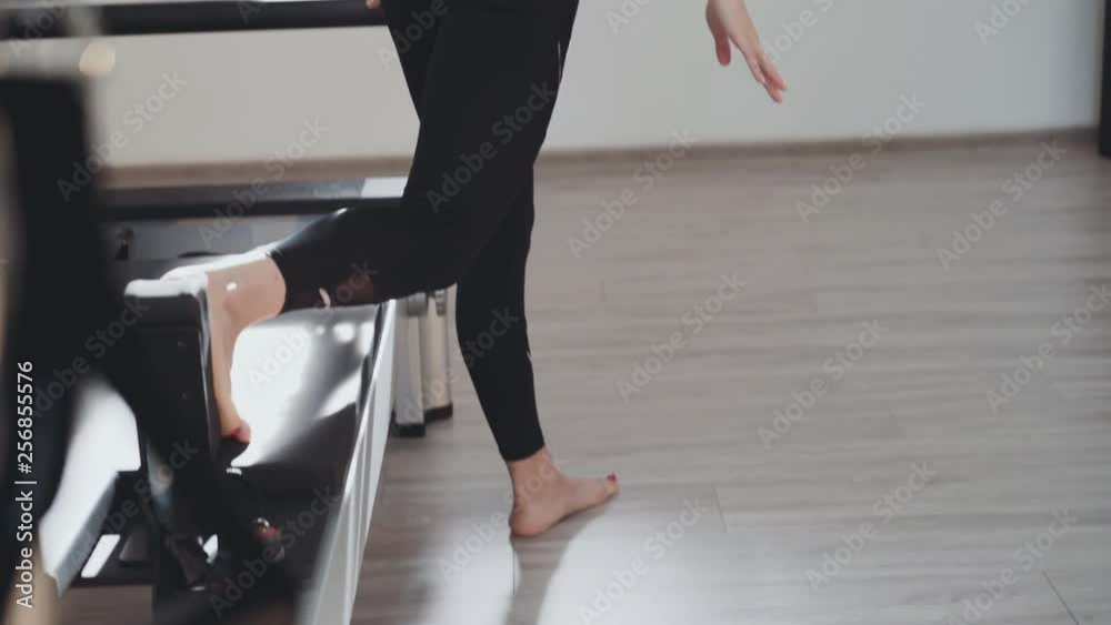 Sport girl doing exercise for legs' stretching with fitness equipment in a gym Sport girl doing exercise for legs' stretching with fitness equipment in a gym