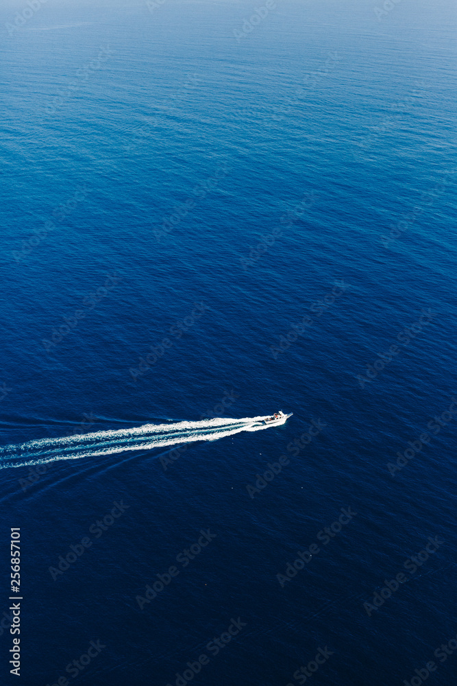 Yacht at the sea in Italy. Aerial view of luxury floating boat on transparent turquoise water at sunny day. Summer seascape from air. Top view from drone. Seascape with motorboat in bay. Yacht at the sea in Italy. Aerial view of luxury floating boat on transparent turquoise water at sunny day. Summer seascape from air. Top view from drone. Seascape with motorboat in bay.