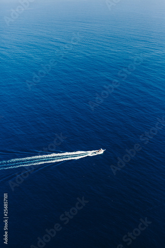 Yacht at the sea in Italy. Aerial view of luxury floating boat on transparent turquoise water at sunny day. Summer seascape from air. Top view from drone. Seascape with motorboat in bay. © smishura
