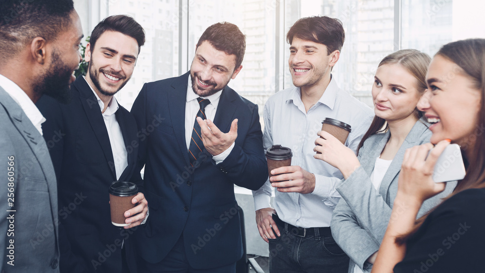 Happy colleagues talking, having coffee break in office Happy colleagues talking, having coffee break in office