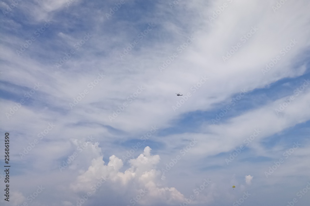 The helicopter is far away in the cloudy sky. The helicopter is far away in the cloudy sky.