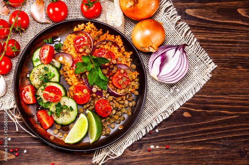 Groats with lentils and vegetables on wooden table