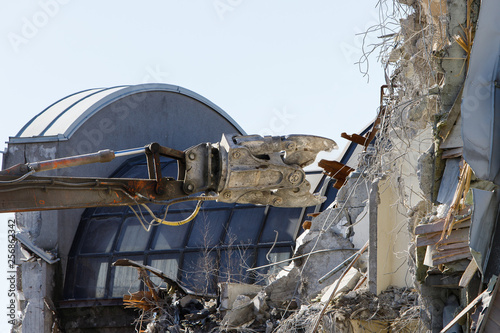 Closeup of demolition of concrete apartment building with hydraulic excavator/hydraulic cutter crane. Making place for new building. 