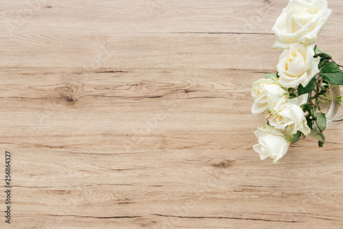 Top view of fresh white roses on wooden surface