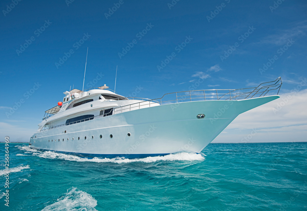 Luxury motor yacht sailing out on tropcial sea