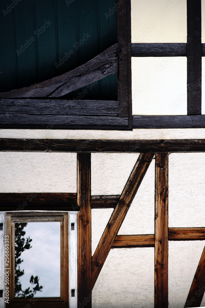 Die Balkenkonstruktion und das Holzgerüst eines nostalgischen Fachwerkhauses mit vergilbter Fassade.. Die Balkenkonstruktion und das Holzgerüst eines nostalgischen Fachwerkhauses mit vergilbter Fassade..