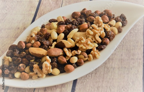 different peeled nuts and raisins on a white elegant plate