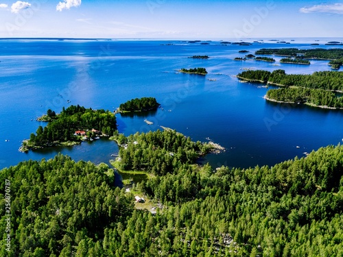 Fototapeta Naklejka Na Ścianę i Meble -  Aerial view of blue lakes and green forests on a sunny summer day in rural Finland.