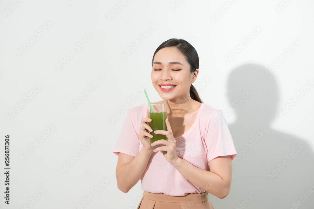 Go green. Young beautiful woman enjoying a healthy raw fruit vegetable juice. Studio shot. Go green. Young beautiful woman enjoying a healthy raw fruit vegetable juice. Studio shot.