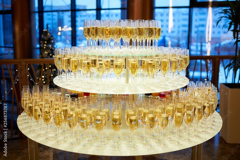 Radial staging of gold champagne glasses on a threetier table in a