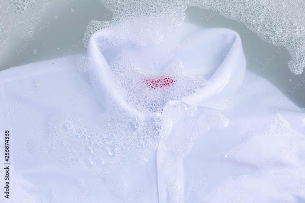 Soak a cloth before washing, white polo shirt. Top view Soak a cloth before washing, white polo shirt. Top view