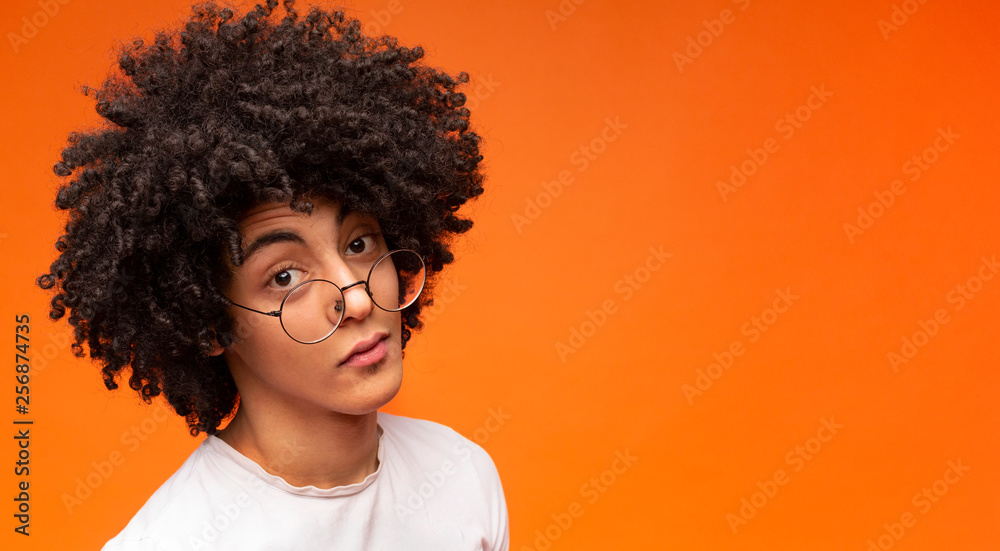 Skeptical man looking suspicious on orange background Skeptical man looking suspicious on orange background