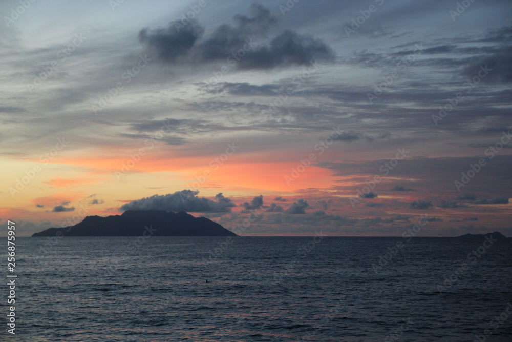 uninhabited island in the ocean against the red sunset uninhabited island in the ocean against the red sunset
