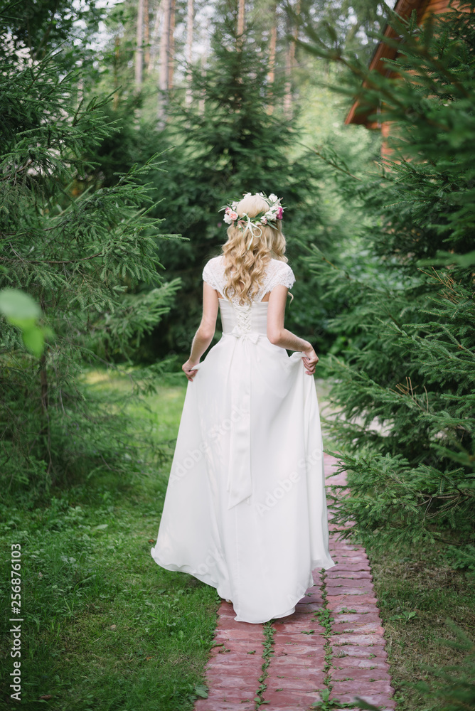 the bride is on the path in the woods