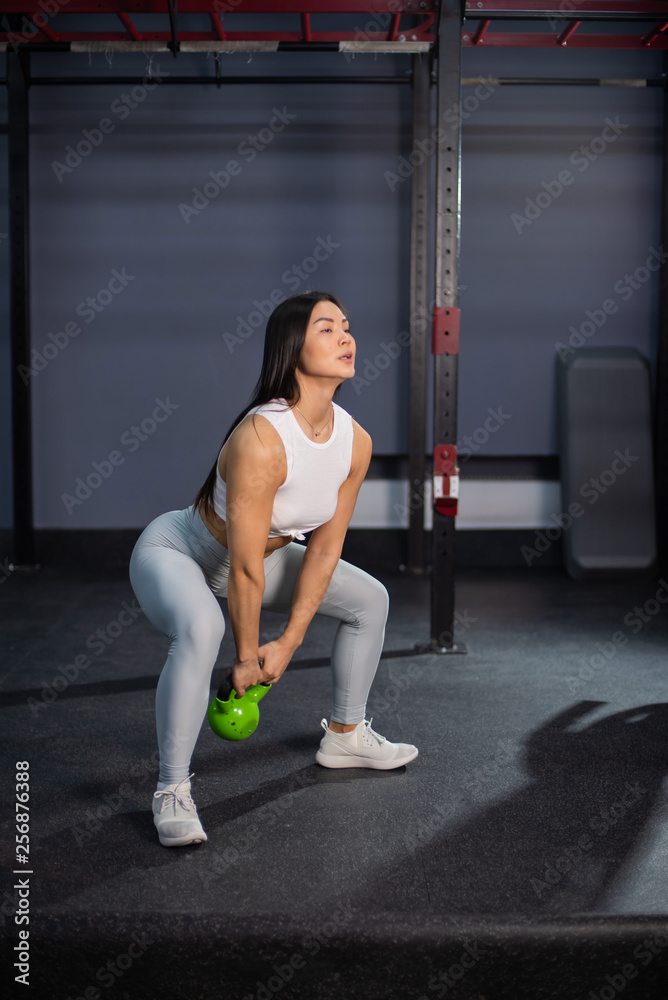 Young asian fitness woman doing exercise. Young athletic woman doing squats with weights Young asian fitness woman doing exercise. Young athletic woman doing squats with weights