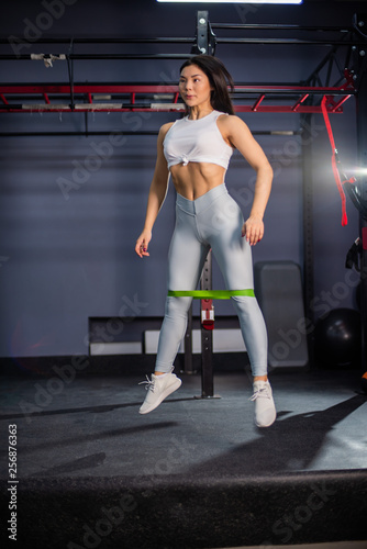 Resistance band exercises with fabric elastic equipment. Asian fitness woman