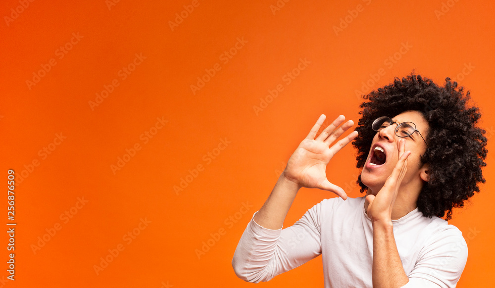 Emotional black guy screaming on orange panorama background - obrazy, fototapety, plakaty 
