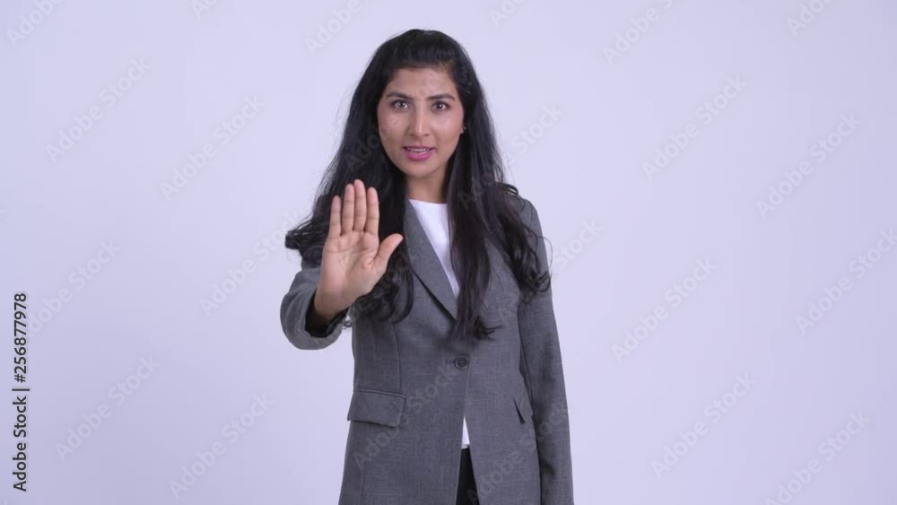 Young serious Persian businesswoman showing stop gesture Young serious Persian businesswoman showing stop gesture