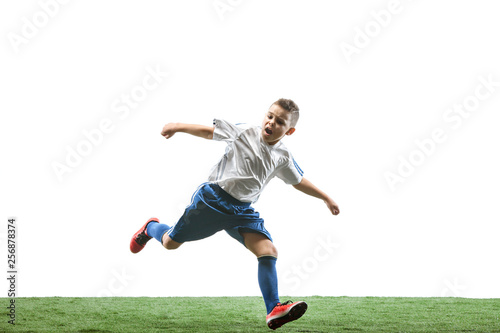 Young boy running and jumping isolated on white studio background. Junior football soccer player in motion