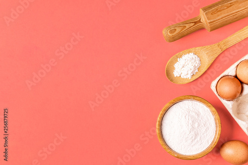 Ingredients and utensils for baking on a pastel background.