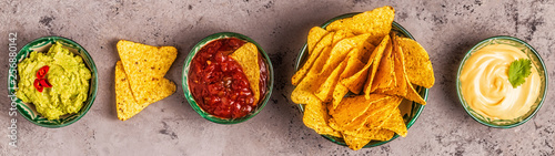 Mexican food background: guacamole, salsa, cheesy sauces with nachos photo