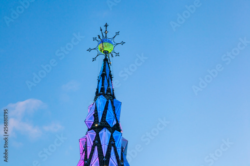 A large and tall multicolored cone with a star on top. The decoration of plastic backlit for the holiday.