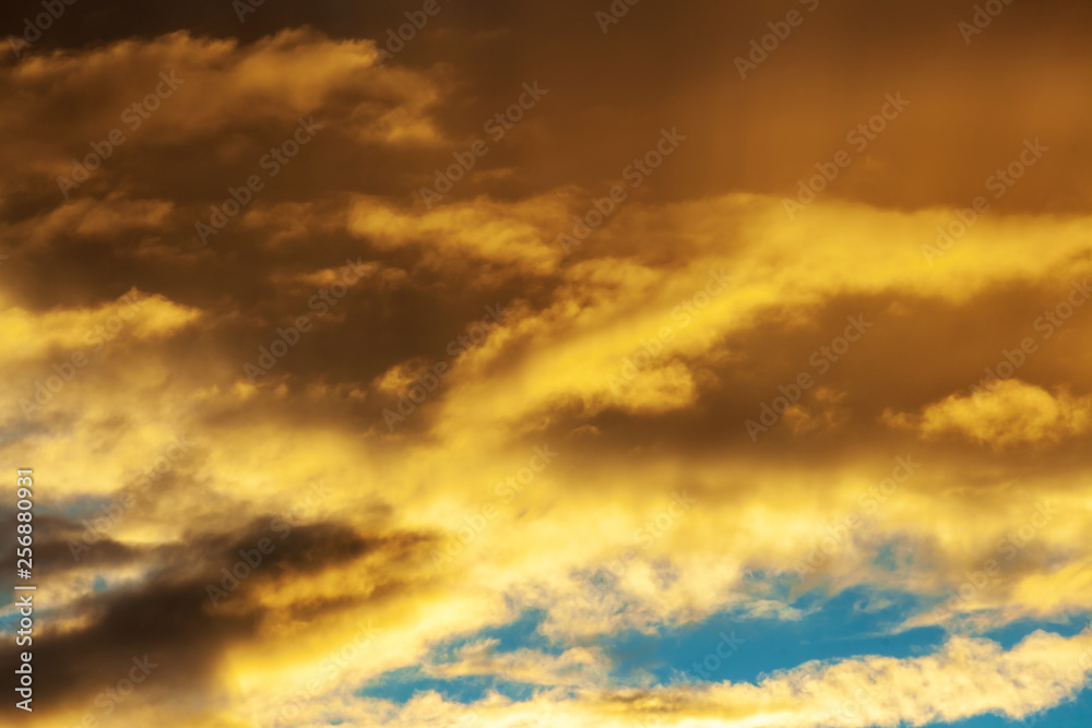 Sunset sky with shades of orange. Background from dramatic cloudy sky.