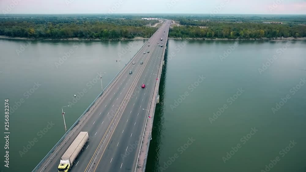 Beautiful view of the bridge over the river, passing cars through the bridge, aerial photography Beautiful view of the bridge over the river, passing cars through the bridge, aerial photography
