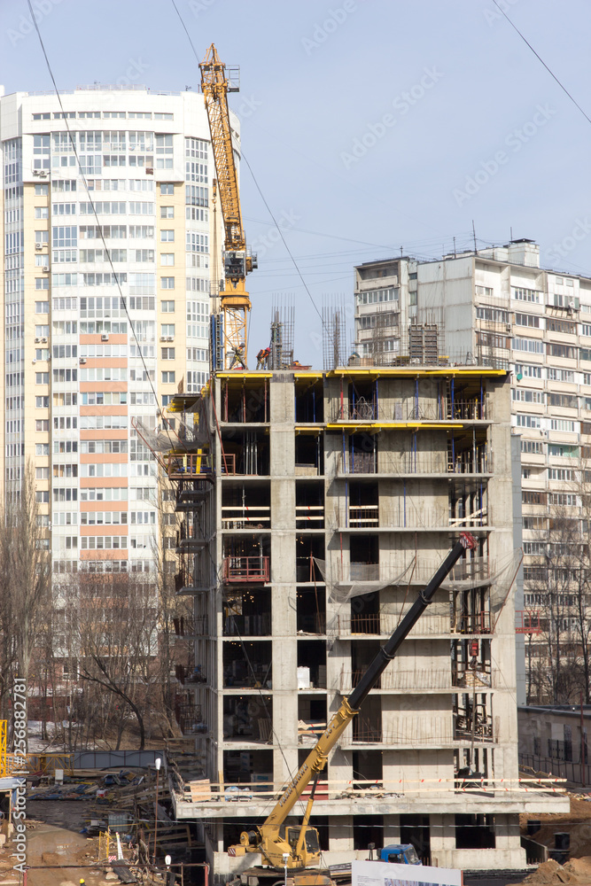construction of a skyscraper high-rise building in the city by builders workers with equipment