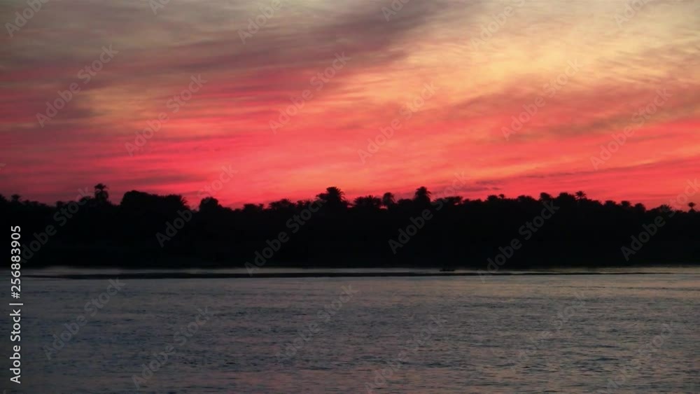 Dramatic Red and Orange Sky in the Evening on the River Nile with Silhouettes of Trees on the Bank of the River Dramatic Red and Orange Sky in the Evening on the River Nile with Silhouettes of Trees on the Bank of the River