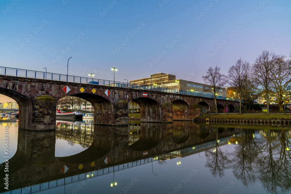Germany, Old bridge of saarbruecken city reflecting in silent water