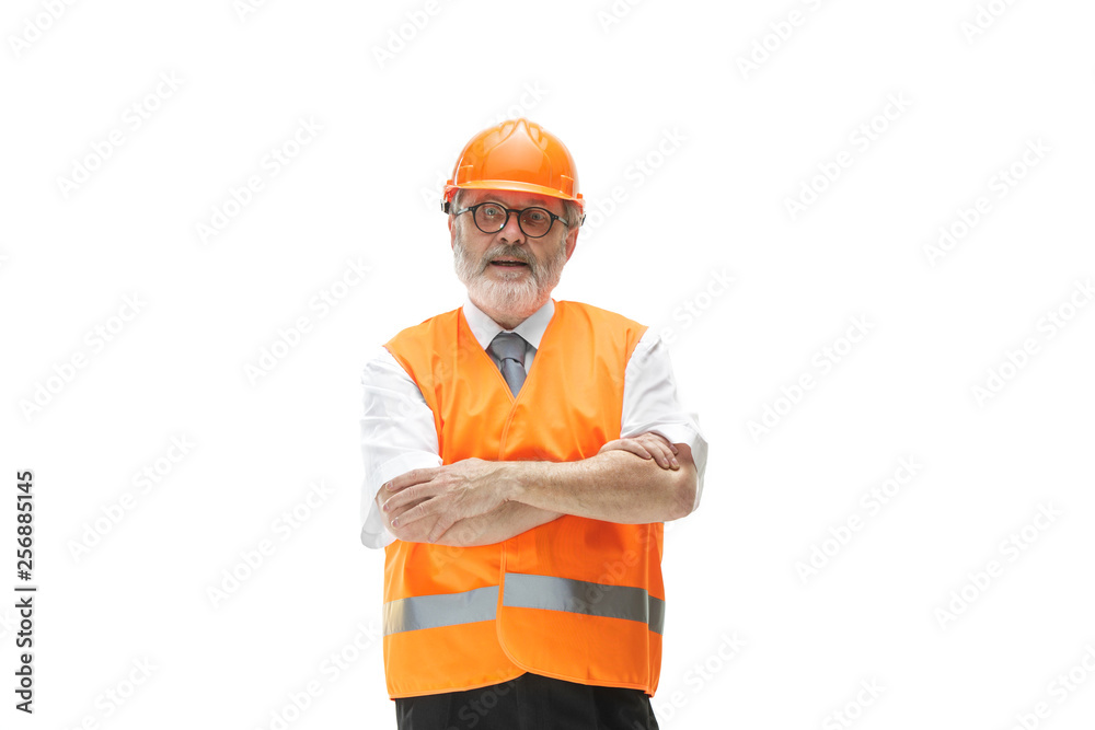 The builder in a construction vest and orange helmet standing on white studio background. Safety specialist, engineer, industry, architecture, manager, occupation, businessman, job concept The builder in a construction vest and orange helmet standing on white studio background. Safety specialist, engineer, industry, architecture, manager, occupation, businessman, job concept