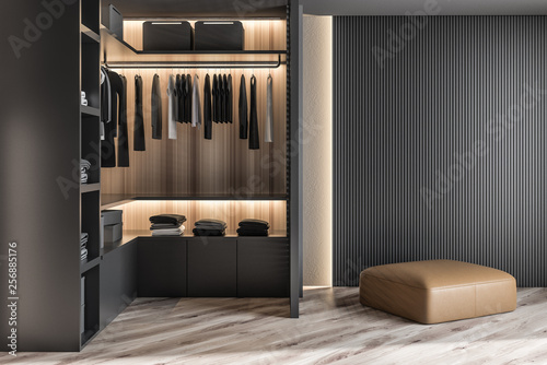 Modern wooden wardrobe with clothes hanging on rail in walk in closet design interior. 3D render photo