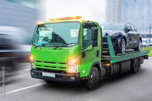 Fotografie Passenger car loaded onto a tow truck for transportation, delivered to the destination