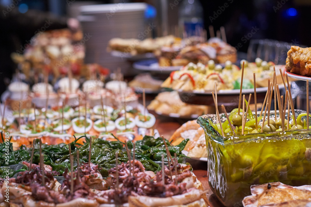 Obraz premium Pinchos i tapas typowe dla Kraju Basków w Hiszpanii. Wybór różnych rodzajów żywności do wyboru. San Sebastian