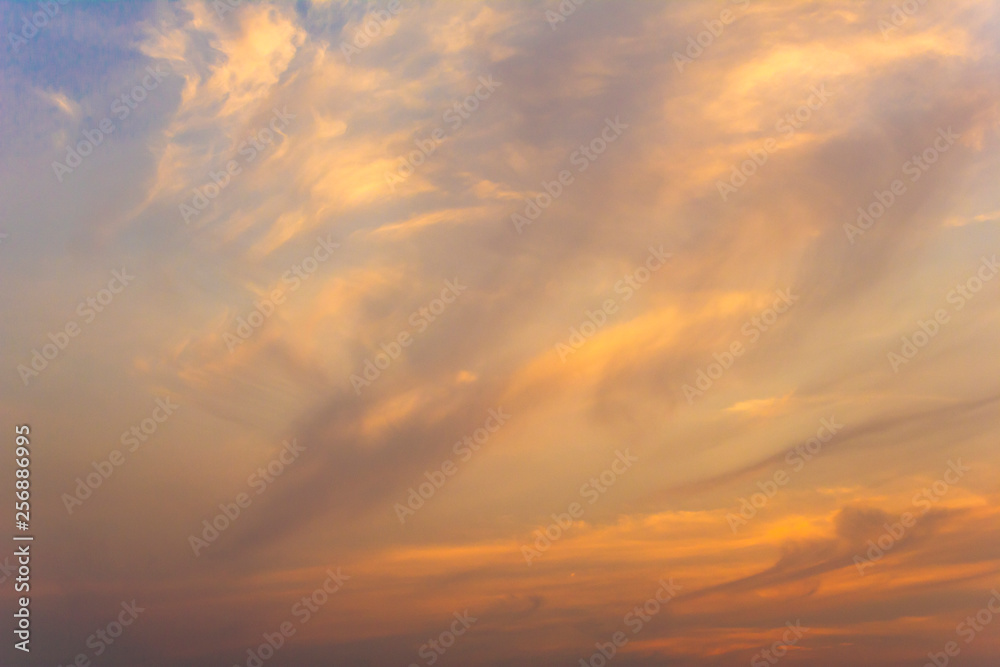 bright white and orange clouds in the blue sunset sky
