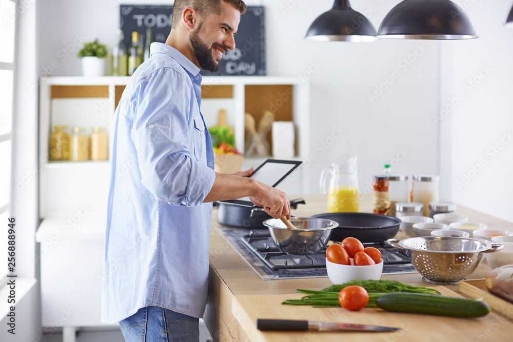 Smiling and confident chef standing in large kitchen Smiling and confident chef standing in large kitchen