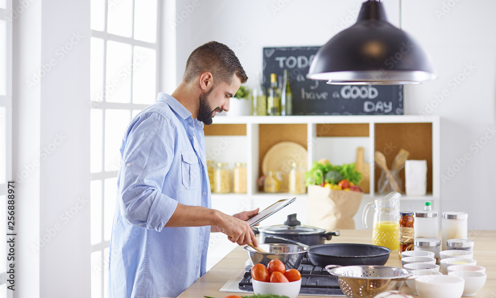 Smiling and confident chef standing in large kitchen