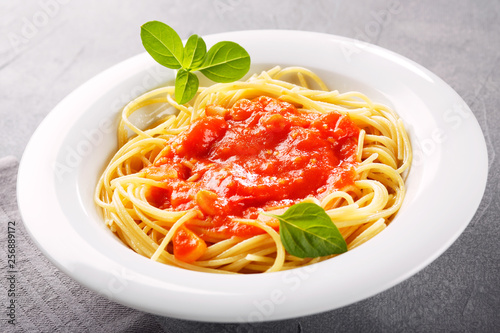 Italian food background with vine tomatoes, basil, spaghetti, olive oil.